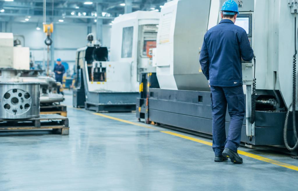 Fabrika üretim hattında iş ayakkabısı ile yürüyen operatör
